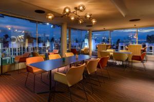 a restaurant with tables and chairs and a view of the city at Barceló Valencia in Valencia