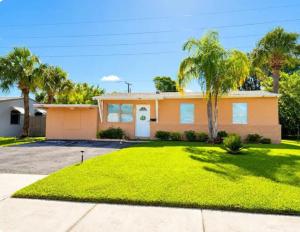 a house with palm trees in front of it at Perfect Family Group Getaway in West Palm Beach