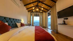 a bedroom with a large bed with a large window at Cliffs & Clouds in Bhīm Tāl