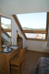 a bedroom with a desk with a chair and a window at Hostal Casa Isabel in Portonovo +45 photos