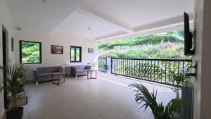 a living room with a view of a balcony at Cliffs & Clouds in Bhīm Tāl