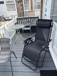 a black rocking chair and a table on a porch at 78 Belle Aire in Hemsby