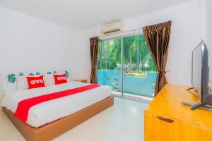 a bedroom with a bed and a tv and a window at Koh Lak Resort in Prachuap Khiri Khan +68 photos