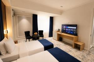 a hotel room with a bed and a flat screen tv at Friday Old City Hotel in Tashkent