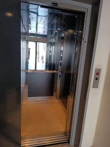 ein leerer Glasaufzug in einem Gebäude in der Unterkunft Elias Appartment in Volos