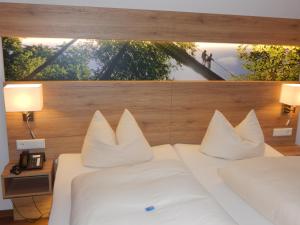 a bedroom with two white beds and a large window at Hotel & Gasthof Hubertushöhe - Ihr Hotel für Urlaub mit Hund in Schmallenberg