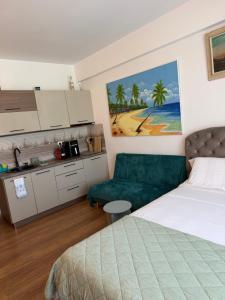 a bedroom with a bed and a green couch at Studio Blaxy Mihnea in Douăzeci şi Trei August
