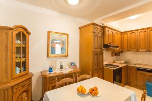 a kitchen with wooden cabinets and a table with fruit on it at Apartment Dubrovnik Pile in Dubrovnik