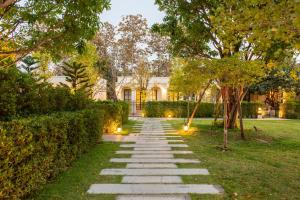 a stone path in front of a house with lights at Kaysorn Siri in Ban Kham Kom