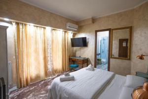 a bedroom with a white bed and a television at Casa Romana in Tor Vergata +21 photos