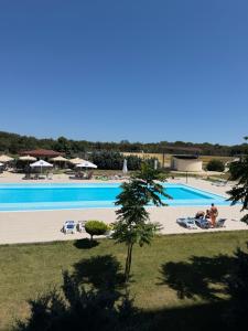 a large swimming pool with people laying on the beach at Studio Blaxy Mihnea in Douăzeci şi Trei August