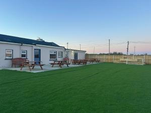 a patio with picnic tables and a green lawn at Cortoon Inn in Tuam