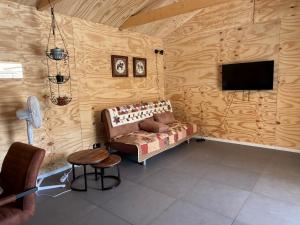 a living room with a couch and a flat screen tv at B&B Tinkunakama in Ouddorp