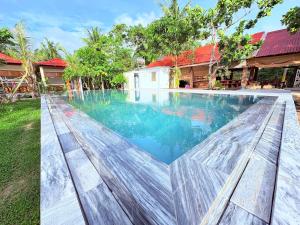 a swimming pool in the backyard of a house at Orchard Fruit Farm Bungalow in Phú Quốc