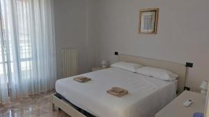 a bedroom with a white bed with two towels on it at A Casa di Nonna Lidia in Crotone