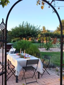 a table with a white tablecloth and chairs in a garden at Gîte Lavande - Le Jardin Secret du Ventoux in Modène +65 photos