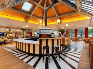 a large kitchen with a bar in a restaurant at Le Saint Gervais Hotel & Spa Handwritten Collection in Saint-Gervais-les-Bains