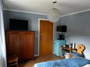 a bedroom with a bed and a tv and a door at Privathaus Sieglinde in Sondermoning