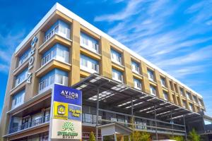 a yellow building with a sign in front of it at Avior Hotel in General Santos