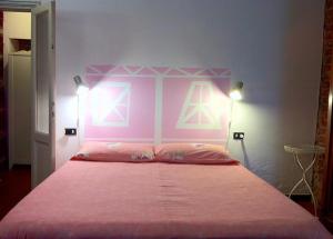 a bedroom with a pink bed with a pink headboard at I tre jack Malpensa in Case Nuove