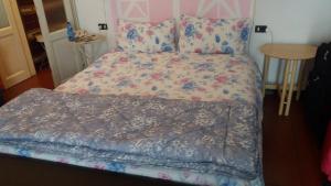 a bed with a floral comforter in a bedroom at I tre jack Malpensa in Case Nuove