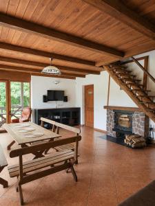 a living room with a table and a fireplace at Medaus slėnis in Šilinė