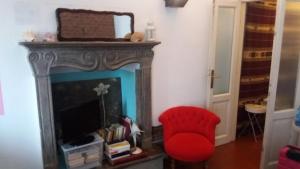 a living room with a red chair and a fireplace at I tre jack Malpensa in Case Nuove