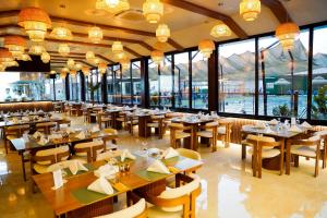 a restaurant with tables and chairs and large windows at Ras Al Khaimah Hotel in Ras al Khaimah