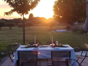 a table with a white table cloth and candles on it at Gîte Lavande - Le Jardin Secret du Ventoux in Modène