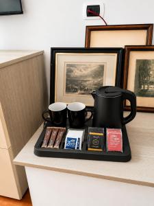 a tray with a tea pot and two cups on a counter at La Villa Del Parco in Monza