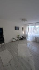 a living room with white walls and a flat screen tv at Ploiești Centru in Ploieşti