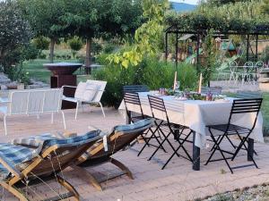 a table with chairs and a white table and chairs at Gîte Lavande - Le Jardin Secret du Ventoux in Modène