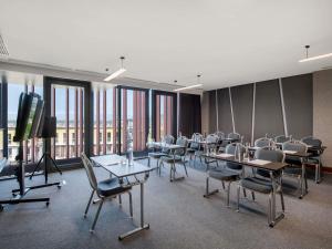 a conference room with tables and chairs and a flat screen tv at Tbilisi Philharmonic Hotel by Mercure in Tbilisi City