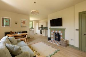 a living room with a couch and a fireplace at The Lodge at Dabton House in Carronbridge