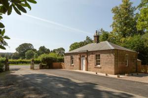 a small brick building on the side of a road at The Lodge at Dabton House in Carronbridge