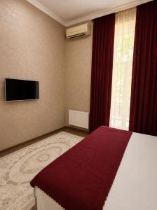 a hotel room with a bed and a tv at La Casa Boutique Nizami in Baku