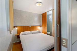 a small bedroom with a white bed and a mirror at Camping La Chiocciola a Capannole in Capannole +35 photos