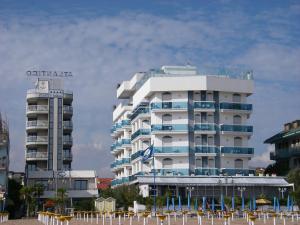 a large white building with chairs in front of it at Residence Atlantico in Lido di Jesolo