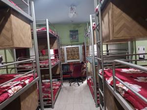 a room with three bunk beds and a desk at Hostel Relax Homestay in Gaya +14 photos