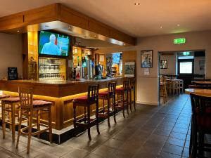 a bar with chairs and a television in a restaurant at Cortoon Inn in Tuam