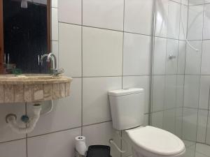 a bathroom with a toilet and a sink at Hospedagem da Néli 2 in Aparecida