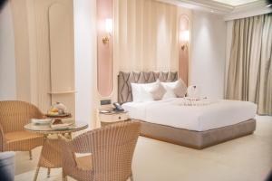 a bedroom with a bed and a table and chairs at The Surya Golden Palace, Pushkar in Pushkar +145 photos