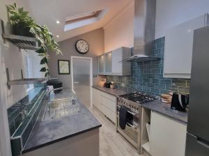 a kitchen with a sink and a clock on the wall at Central Cambridge -comfortable Victorian Terrace in Cambridge