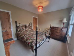a bedroom with a bed and a wooden dresser at Central Cambridge -comfortable Victorian Terrace in Cambridge
