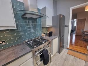 a kitchen with a stove and a refrigerator at Central Cambridge -comfortable Victorian Terrace in Cambridge +9 photos