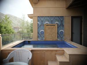a swimming pool on a balcony with a table and a chair at The Surya Golden Palace, Pushkar in Pushkar