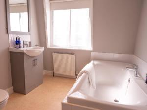 a white bathroom with a tub and a sink at The Old Reading Rooms Linton in Linton