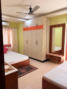 a bedroom with two beds and a mirror at Mi casa homestay in Guwahati