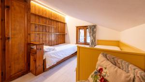 a small bedroom with a bed and a window at Casa Amabile in Cortina dʼAmpezzo