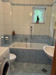 a bathroom with a tub and a toilet and a sink at M5 in Promajna +6 photos